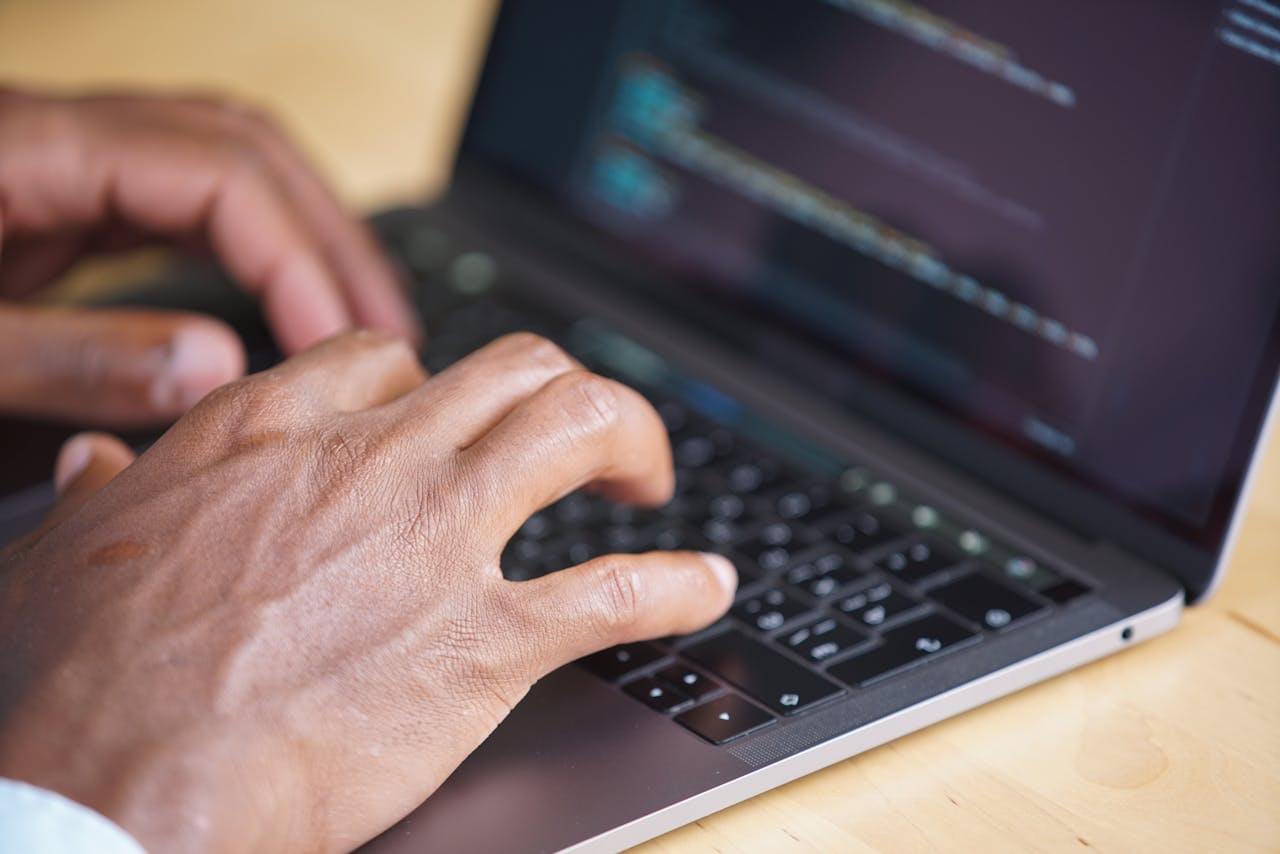 Руки набирают программный код на клавиатуре